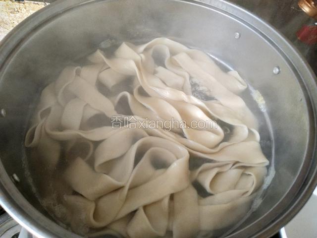 锅里水烧开下入扯好的面再次煮开，一共煮开三次，每开一次点少许凉水，最后一次煮开的时候放入豆芽和青菜