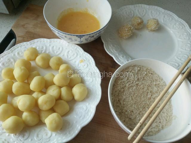 把土豆球先裹上蛋液，再裹上面包糠。