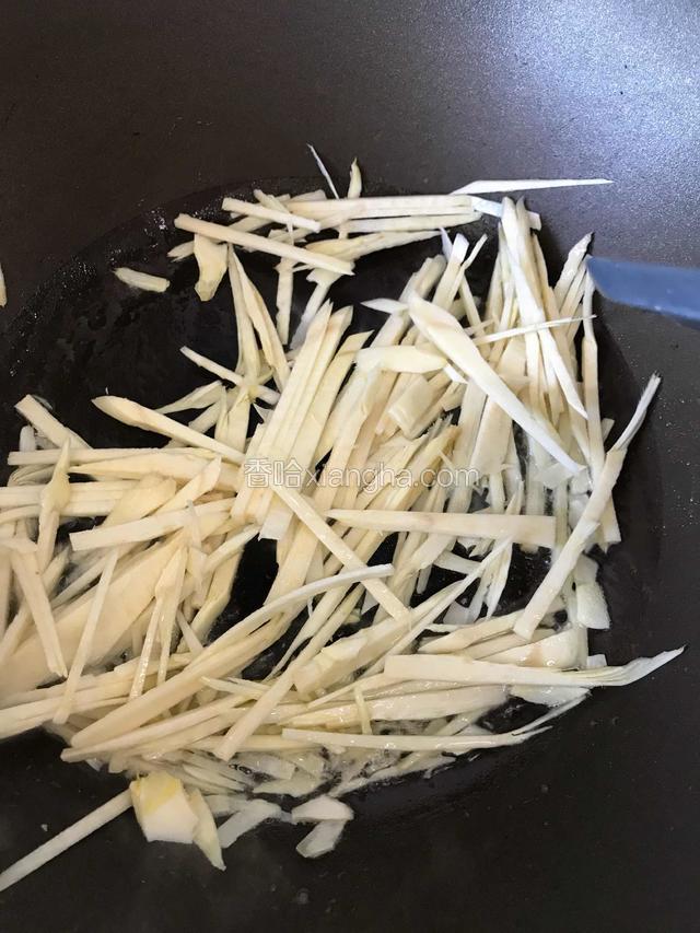热锅凉油加入笋丝加适量盐炒香，