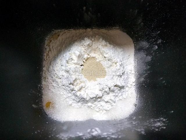 再放入两种面粉，糖和盐对角放，中间放酵母