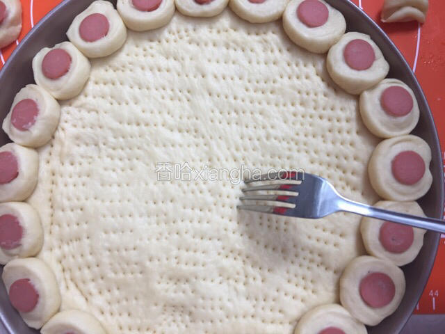 沾少许水粘在饼面周围，叉子在饼面扎孔排气
