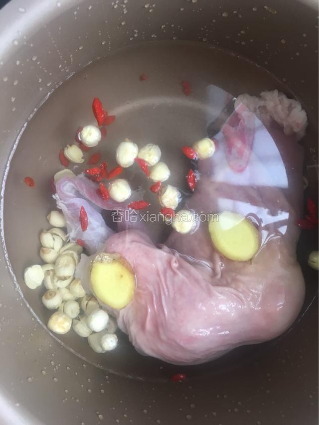 把洗好了莲子，猪肚，枸杞，姜片，清水一起放入电饭煲的内胆里