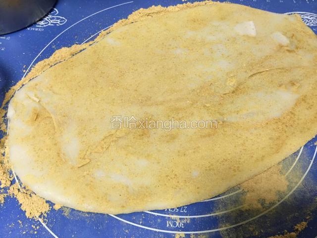 蒸熟的面团放在黄豆面上擀开