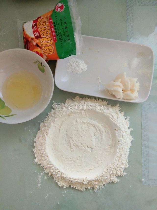 将所需要的食材称重，把面粉放在案板上， 中间挖开一个洞，