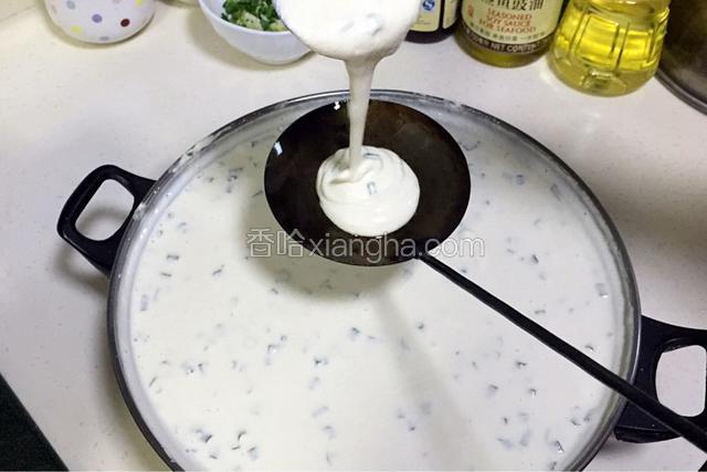 待油温加热超过180度时，从锅内取出油饼勺，往油饼勺内倒入一勺豆米浆。