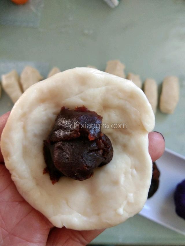切成大小一样的小块。揉成圆形，压扁，中间？包入豆沙或紫薯馅，用虎口收紧，包成圆型
