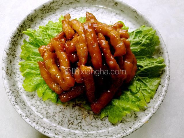 把炒好的里脊肉盛在铺了生菜叶的盘中。
