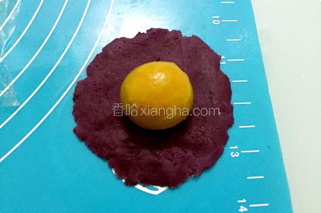 把紫薯馅按扁放入蛋黄