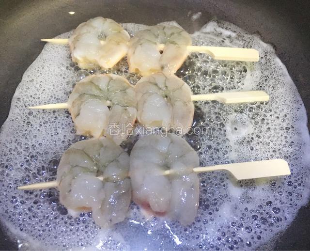 锅加热倒入蜂蜜柠檬汁摆好虾串煎制