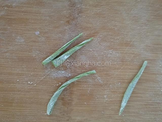 把绿色的和口口面团擀成片，切成细丝。