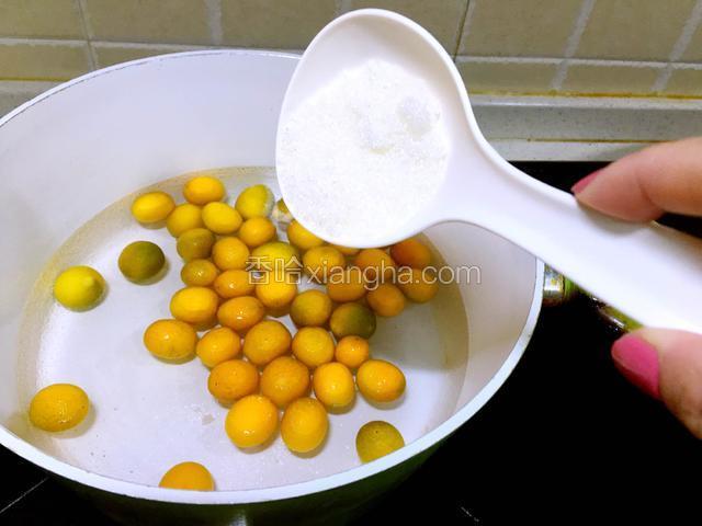 锅里注水，放入金桔，煮的水开始微微冒泡，倒入白糖