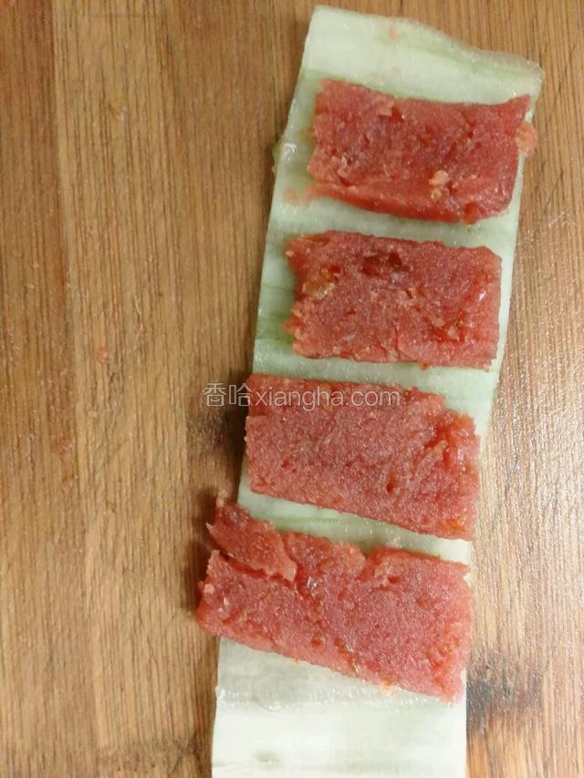 把山楂放在削好的黄瓜片上，从一头卷起来，切段。