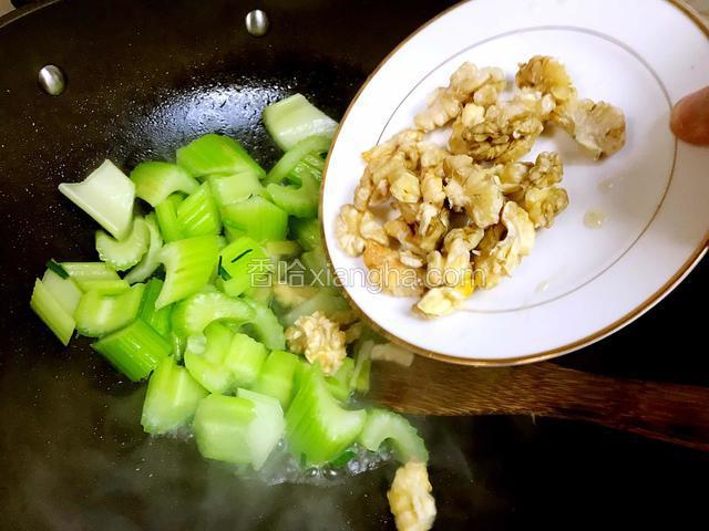 西芹颜色变翠绿后加入核桃仁再翻炒约1分钟