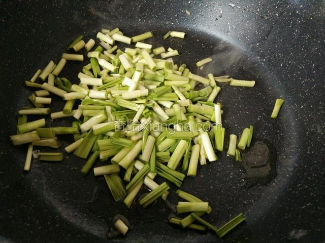 锅里烧油，青蒜段根部先炒