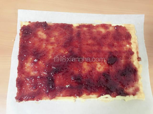 趁着余温在蛋糕上抹上一层草莓果酱，切掉四个边角