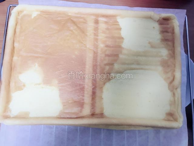 将出炉的蛋糕倒扣在烤网上，撕去底部的油纸，让其放凉