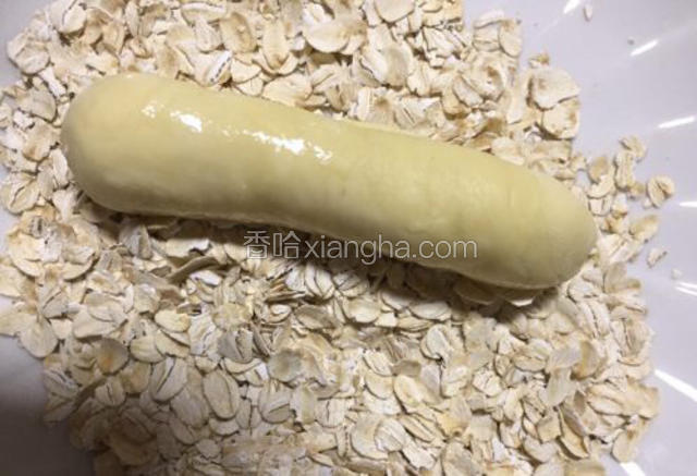 在面包胚表面沾水放在燕麦片盘里滚一圈