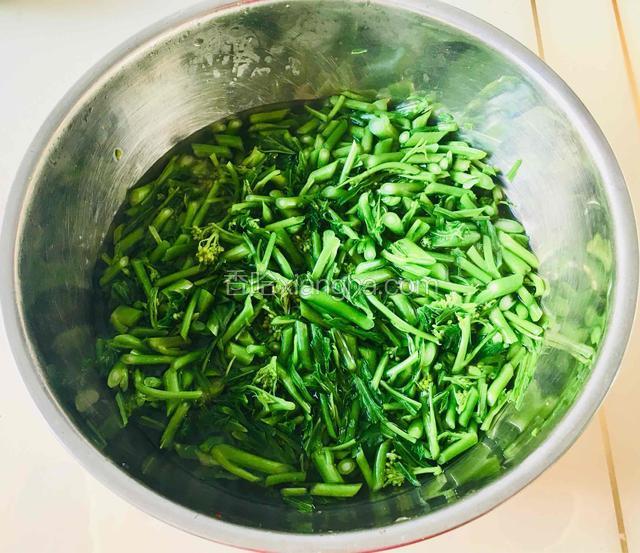 将揽好的菜苔捞起连同少许汤汁放入盆中，继续用筷子翻拌几下。
