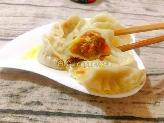 煮好的水饺成品图（锅中倒入适量的水，煮开大滚后，放入饺子，立刻用漏勺由上往锅底推动。 煮至至水饺浮起，颜色变白即熟，捞起后沥干水分，盛盘。酱着番茄酱或者酱油食用）