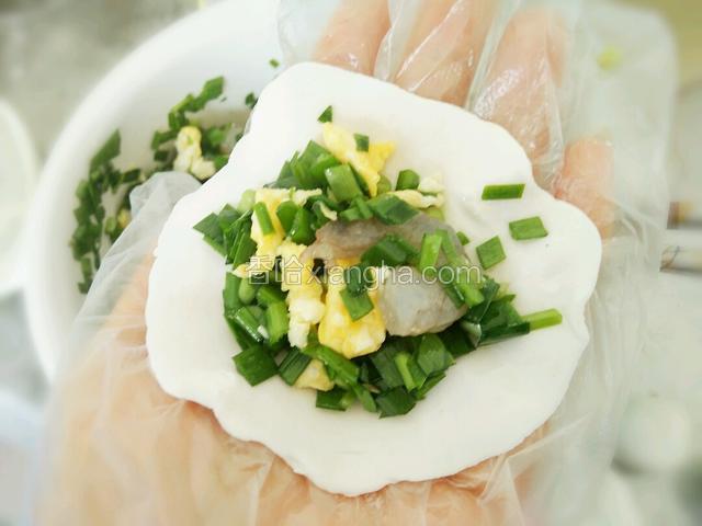 用手掌心压扁包入馅料