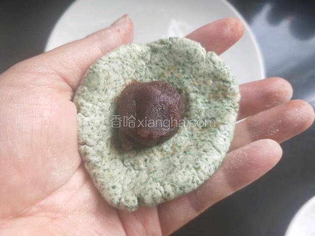 将糯米团分成45g一个，用手捏平，放入豆沙。