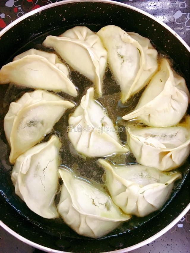 倒入清水，水量莫过水饺的一半，盖上锅盖焖煎