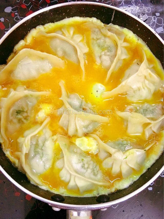 水份收干后从锅边与水饺间缝隙的地方倒入鸡蛋液，煎煮至鸡蛋完全凝固