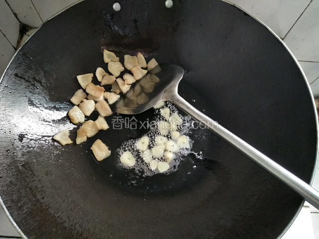 猪油渣炸好移到一旁，放入蒜片爆香