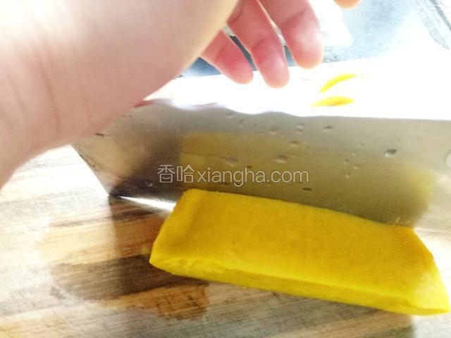 将黄元米果切成长条状，因为米果会有点硬，所以切的时候注意方法:右手持刀，左手压刀背。这样切会非常轻松