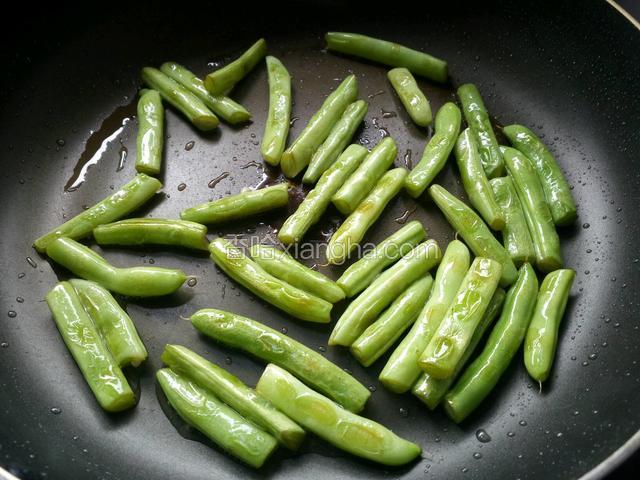 煸炒至豆角皮起皱。