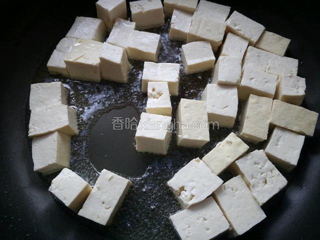 锅烧热后，下入30克花生油，豆腐用油煎。
