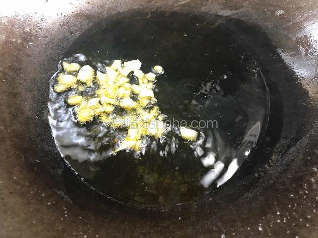 锅烧热油，放入大蒜爆香