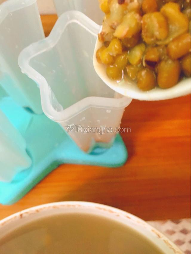 用汤匙把绿豆汤装入模具中，大约九分满即可
