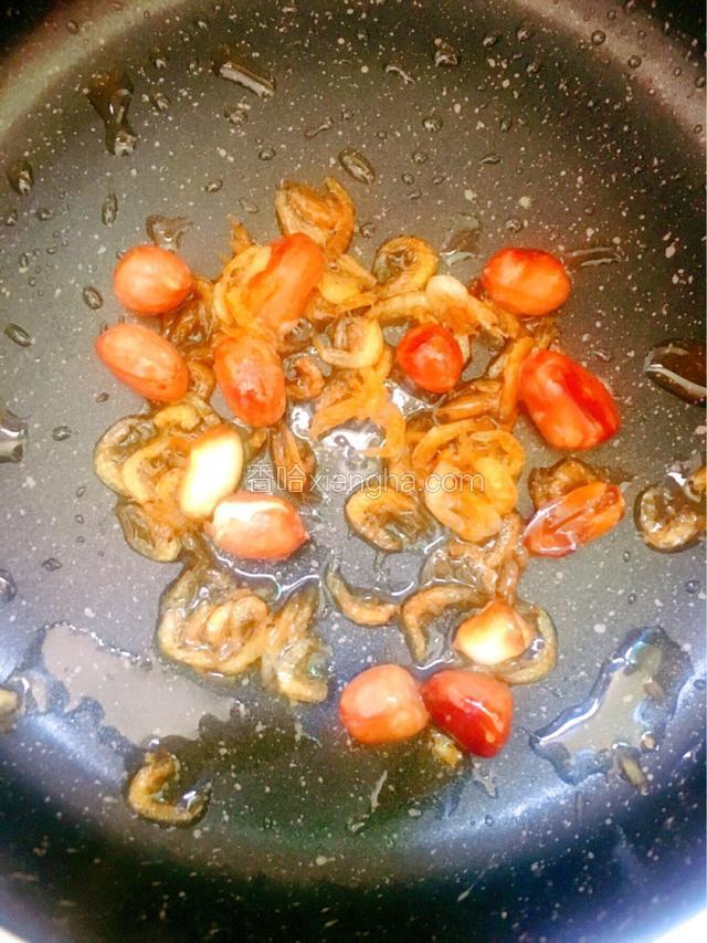下1汤匙油，下入虾皮和花生，小火炒至花生表面微焦，花生酥脆即可盛出备用