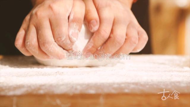 将活好的面团拿出，放在撒有五白糕干粉的案板上开始揉；