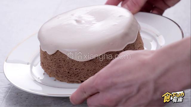 小角度抬起蛋糕，晃动手腕，使巧克力奶油形成自然流下的曲线