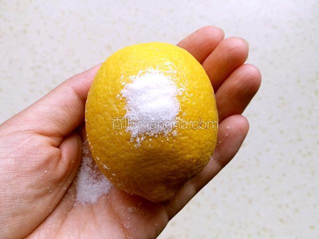 柠檬用水淋湿，放少许食盐，把柠檬搓洗干净