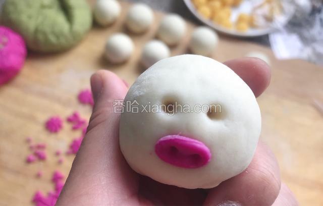 椭圆型做小猪鼻子，在眼睛的位置先用筷子戳两个小孔，再用吸管压两个小圆片按上做眼睛
