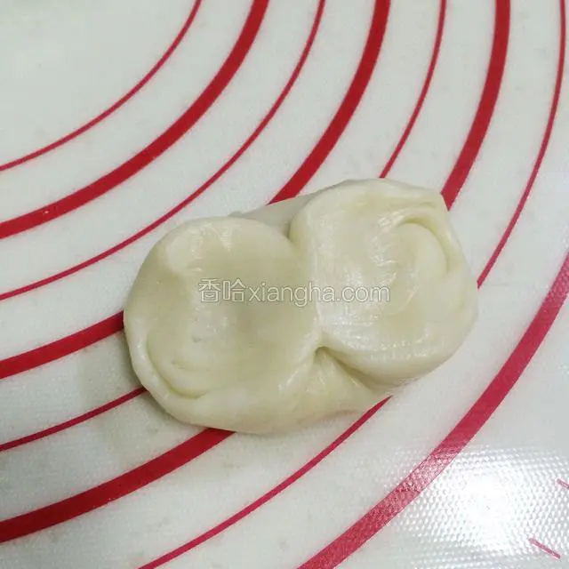 取一份油酥皮对折，两头往中间靠拢，然后按压。