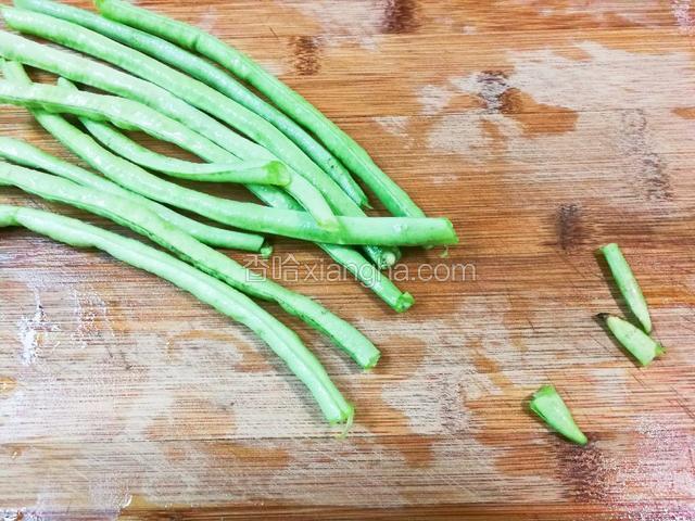 豇豆掐去头尾，撕去丝