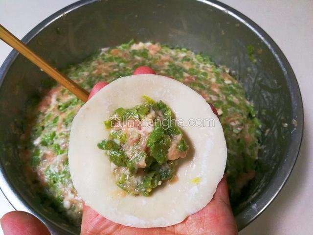 取一张饺皮放入适量馅包起来，煮熟