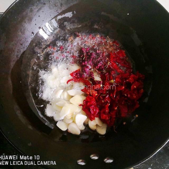 热锅中倒入油，油温7成热时，加入花椒，干辣椒，蒜片中小火炸1分钟