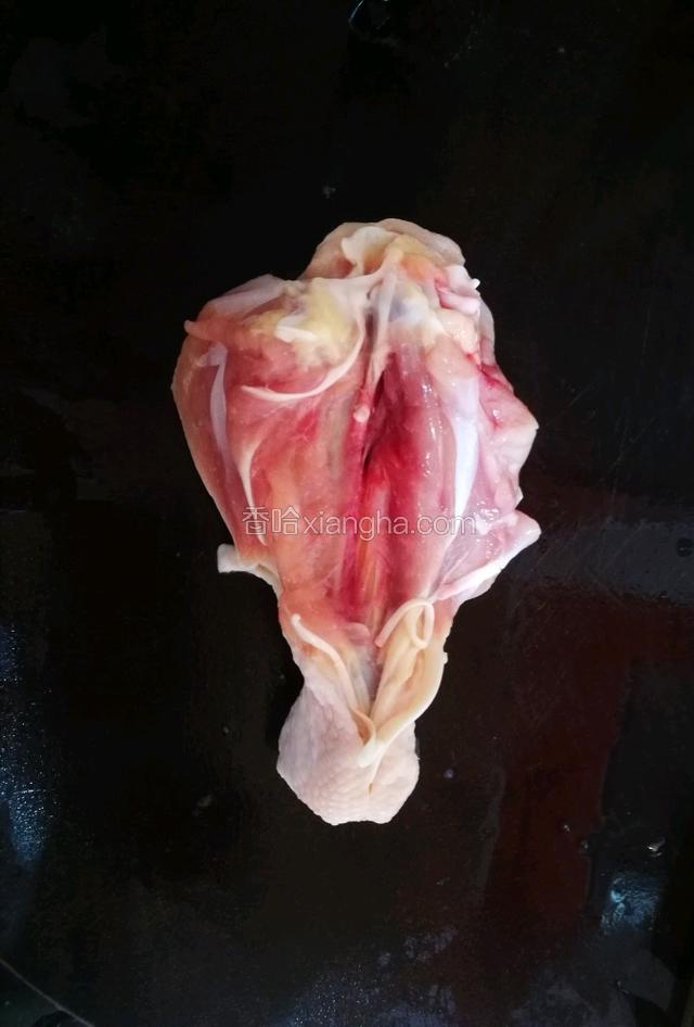 用刀从中间把鸡腿切开。