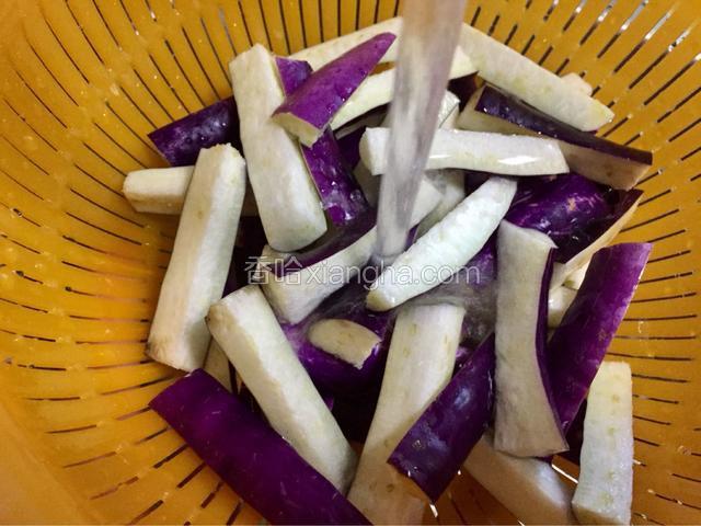 将茄子切条状，用水冲淋，将茄子里的涩汁冲洗掉，同时茄子充满水分，这样炒制的时候就不太费油了！