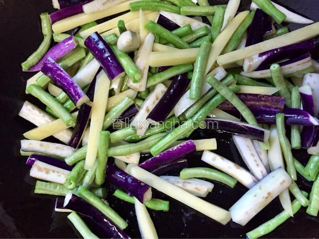将土豆条、茄子条和豆角倒入锅中，中火翻炒，炒至断生