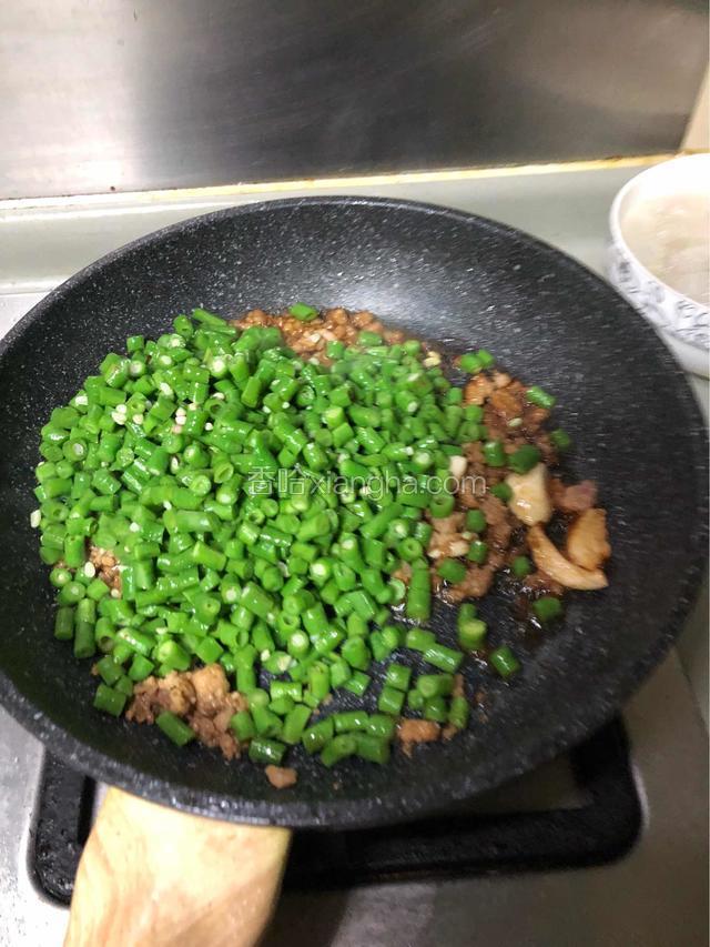 下豆角一起炒，放半勺盐，翻炒二三分钟。