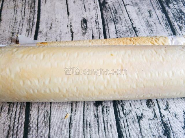 用擀面杖趁热将蛋糕卷起。