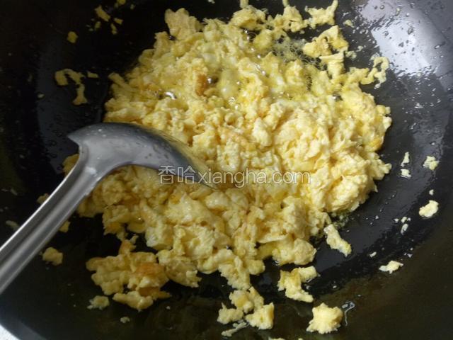  倒入打散的鸡蛋，用勺子炒成小碎块
