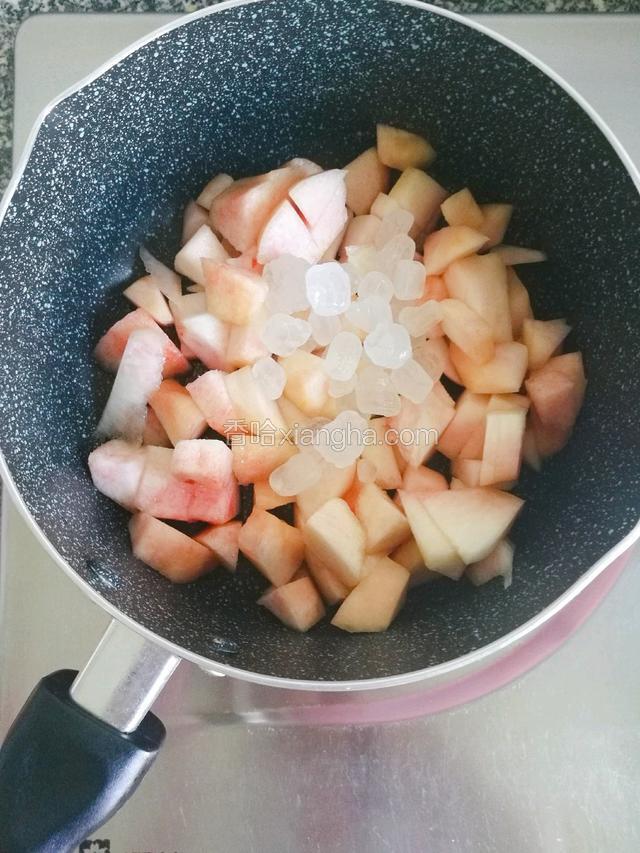 然后将桃子块倒入锅中，加入40冰糖搅拌至出汁。