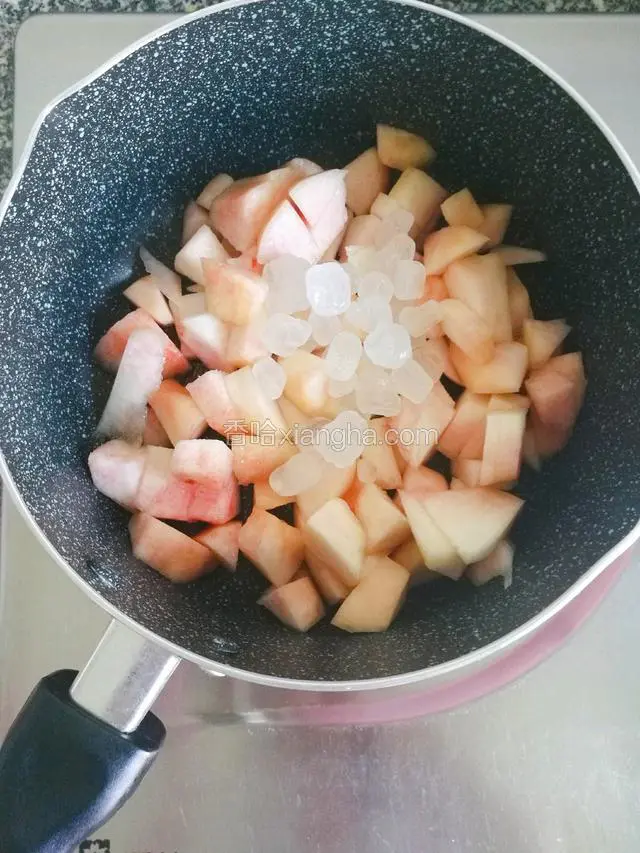 然后将桃子块倒入锅中，加入40冰糖搅拌至出汁。